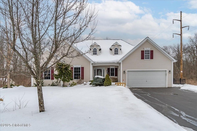 new england style home featuring a garage and aphalt driveway