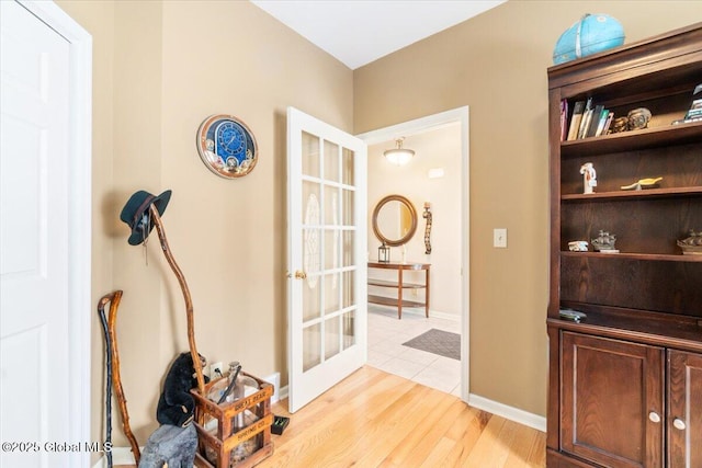 interior space featuring light wood-style floors, french doors, and baseboards