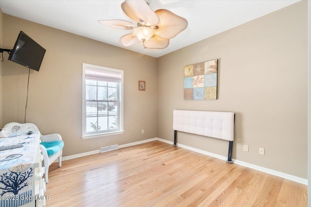 interior space featuring ceiling fan, light wood finished floors, visible vents, and baseboards