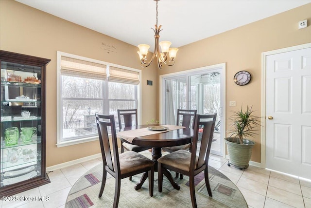 dining room with light tile patterned floors, a chandelier, and baseboards