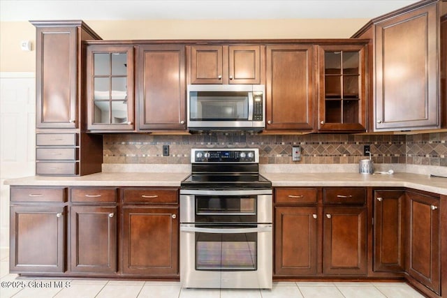 kitchen with backsplash, stainless steel appliances, and light countertops