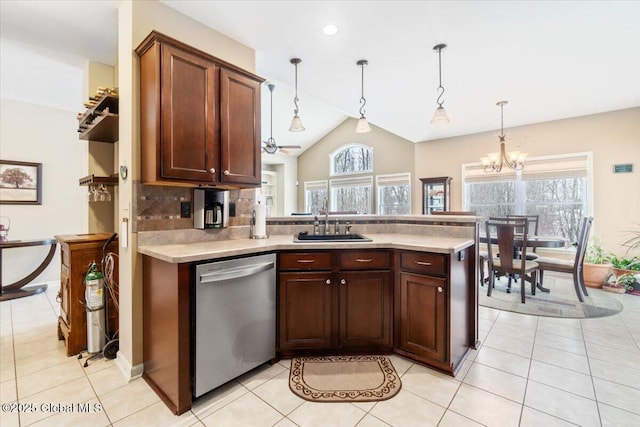 kitchen featuring light countertops, backsplash, stainless steel dishwasher, a sink, and a peninsula