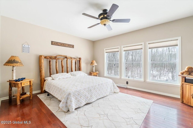 bedroom with multiple windows, visible vents, baseboards, and hardwood / wood-style flooring