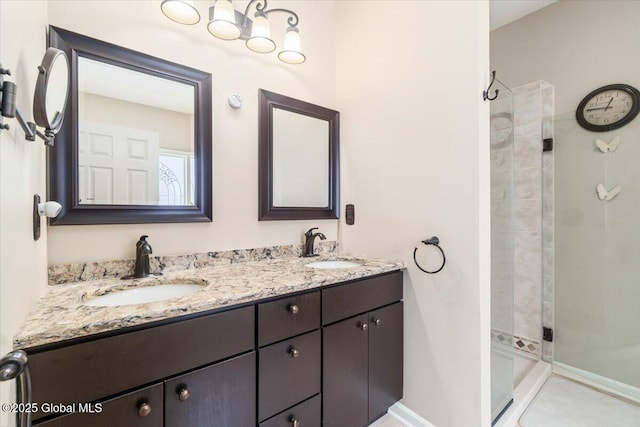 full bathroom with a stall shower, a sink, baseboards, and double vanity