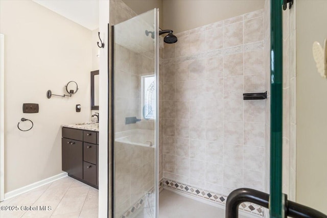 bathroom featuring tile patterned floors, a shower stall, baseboards, and vanity