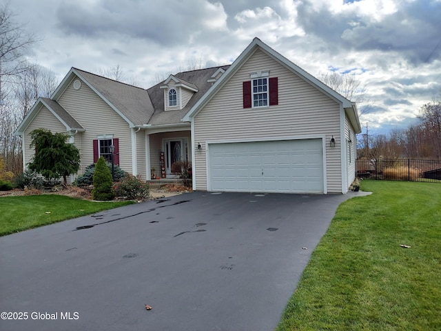 traditional-style home featuring a garage, a front yard, fence, and driveway