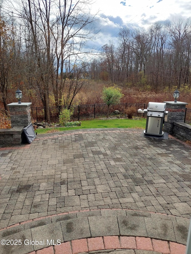 view of patio / terrace with a grill and fence