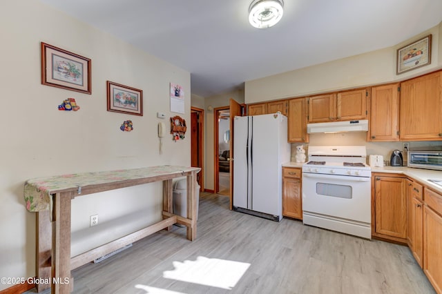 kitchen featuring white appliances, under cabinet range hood, light countertops, and light wood finished floors