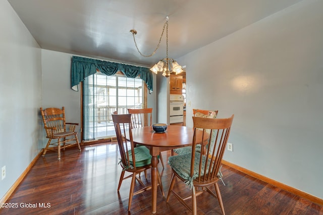 dining area with wood finished floors, baseboards, and a chandelier