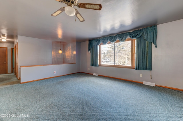 unfurnished room with ceiling fan, carpet floors, visible vents, and baseboards