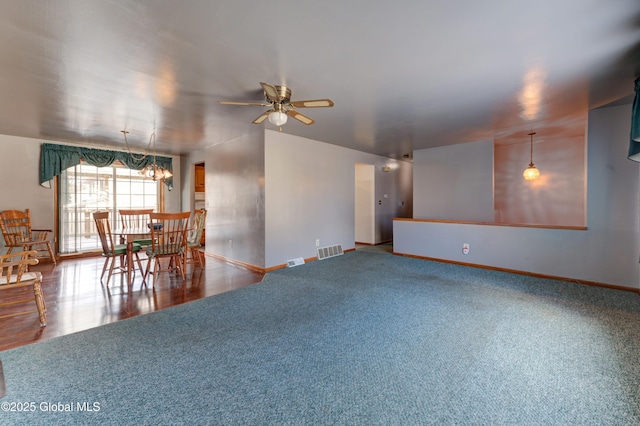 unfurnished living room with baseboards, ceiling fan, and carpet