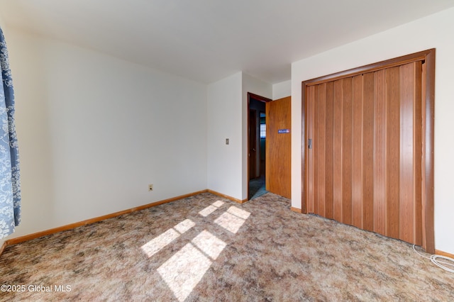 unfurnished bedroom with carpet flooring, a closet, and baseboards