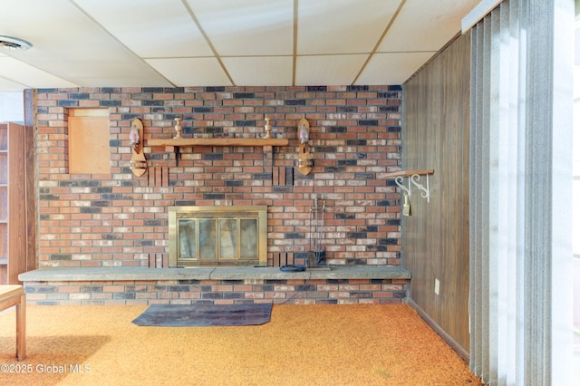 unfurnished living room featuring carpet and a drop ceiling