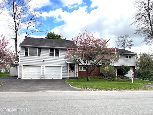 view of front of property with an attached garage, driveway, and a front yard