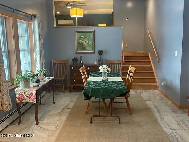 dining room with ceiling fan, stairs, and baseboards