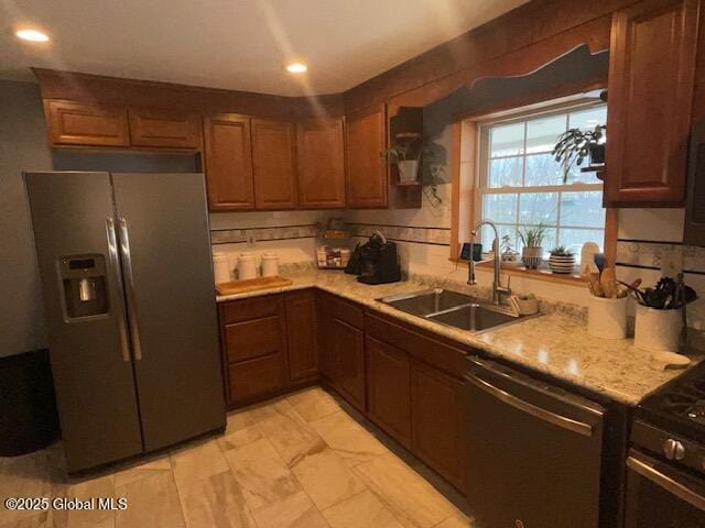 kitchen featuring stainless steel appliances, recessed lighting, light countertops, and a sink