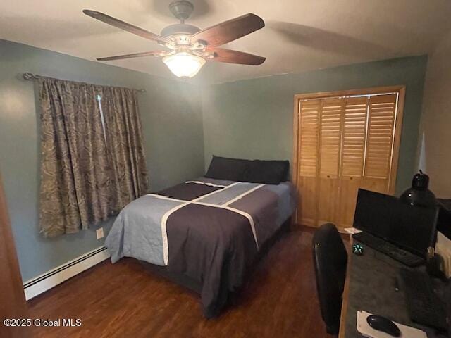 bedroom featuring ceiling fan, a closet, a baseboard heating unit, and wood finished floors