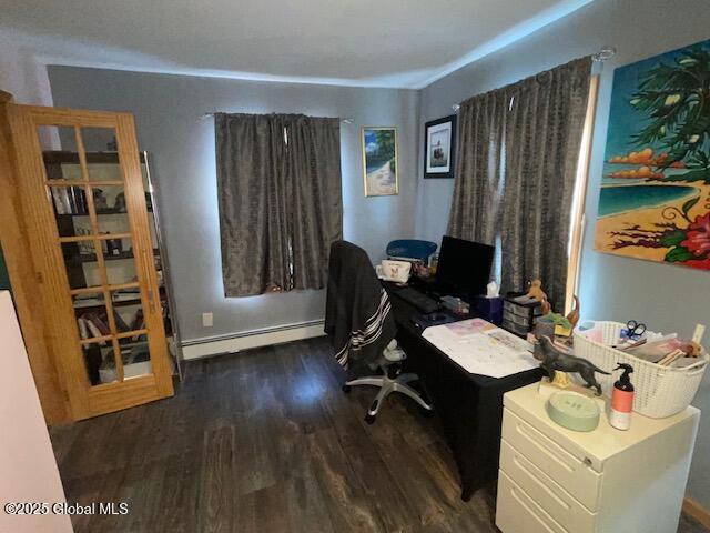 home office with a baseboard heating unit and wood finished floors