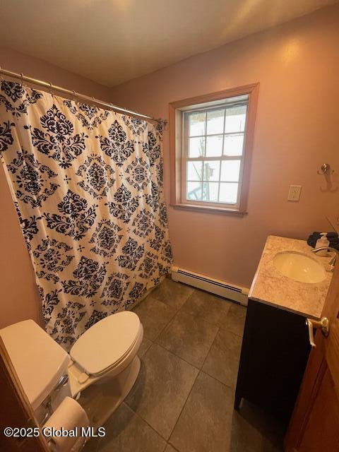 bathroom with curtained shower, toilet, baseboard heating, vanity, and tile patterned flooring