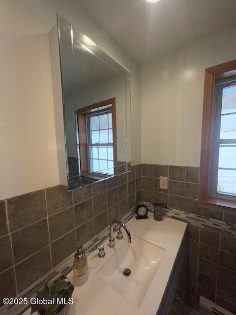 bathroom featuring tile walls and a sink