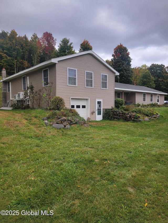 back of property with a garage and a yard