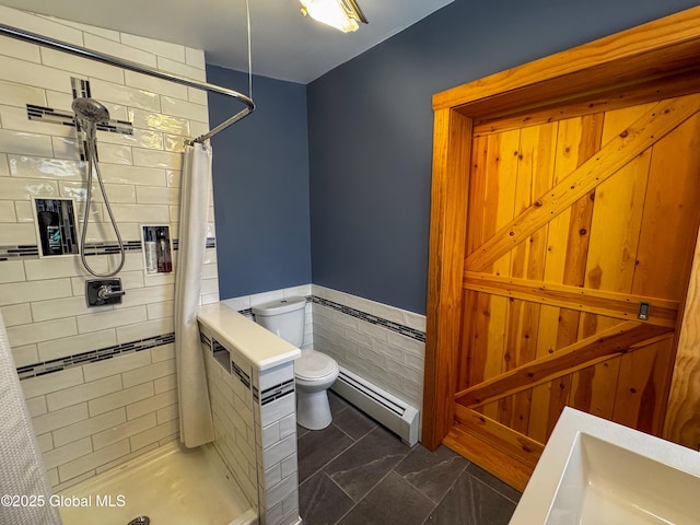 full bathroom featuring toilet, a wainscoted wall, tile walls, baseboard heating, and a shower stall