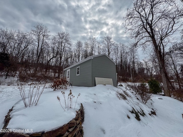 snow covered property with a garage