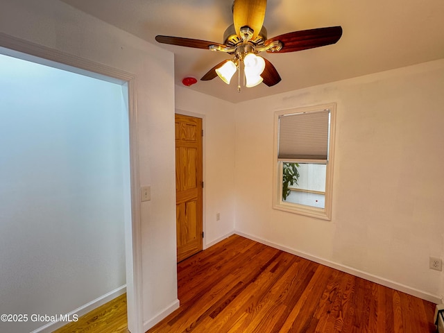 empty room with baseboards and wood finished floors