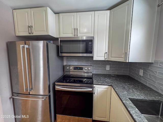 kitchen featuring a sink, white cabinetry, stainless steel appliances, and backsplash