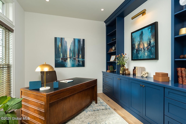 office area with recessed lighting, built in shelves, and light wood-style floors
