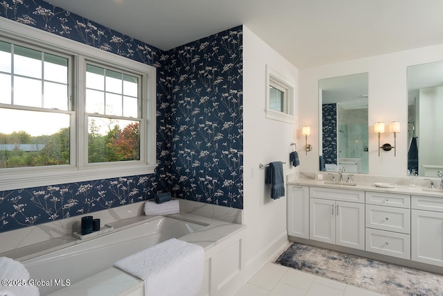 full bathroom featuring a sink, a garden tub, double vanity, and wallpapered walls