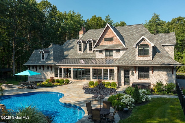 outdoor pool with a patio and outdoor dining space