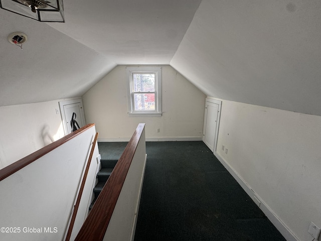 bonus room with vaulted ceiling, baseboards, and dark colored carpet