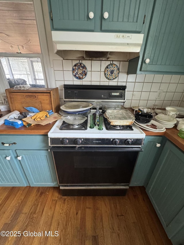 kitchen with under cabinet range hood, decorative backsplash, electric range oven, and dark wood-style floors