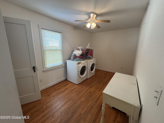 clothes washing area with baseboards, ceiling fan, laundry area, wood finished floors, and washer and dryer