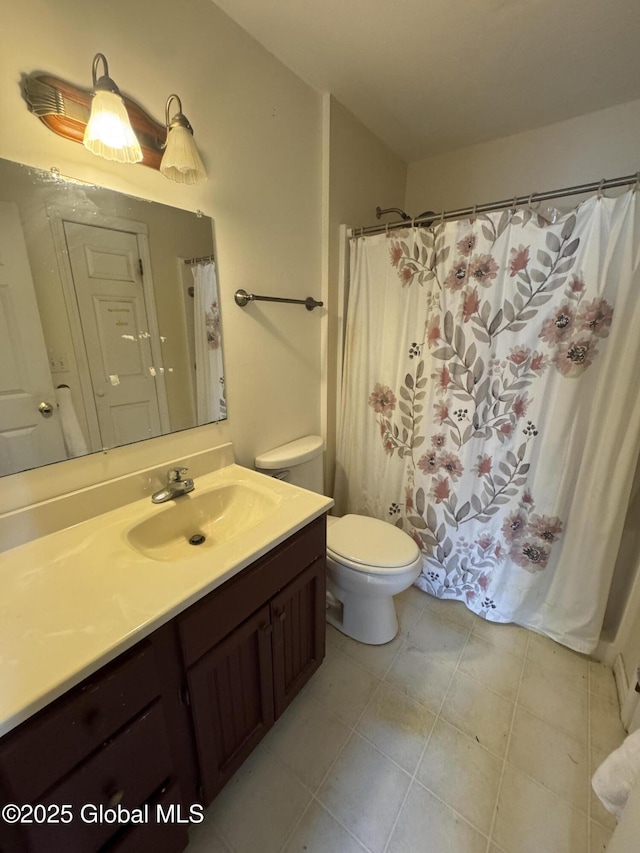 bathroom featuring toilet, vanity, and tile patterned flooring