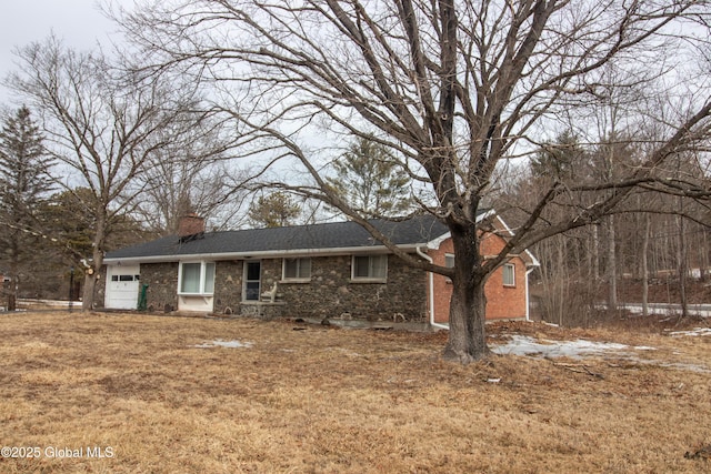 single story home with a garage, brick siding, and a chimney