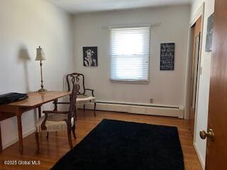 office area featuring baseboard heating and wood finished floors