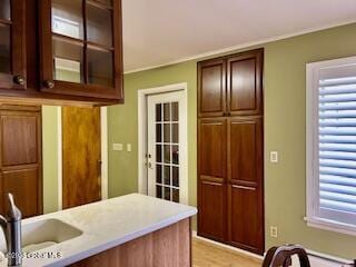 kitchen with a sink, glass insert cabinets, and light countertops