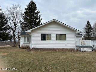 back of property with a yard and a wooden deck