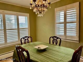 dining space featuring an inviting chandelier, crown molding, and baseboard heating