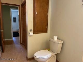 bathroom with tile patterned flooring, toilet, and baseboards