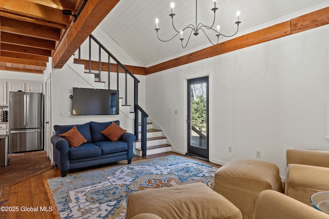 living area with vaulted ceiling with beams, baseboards, dark wood finished floors, a chandelier, and stairs