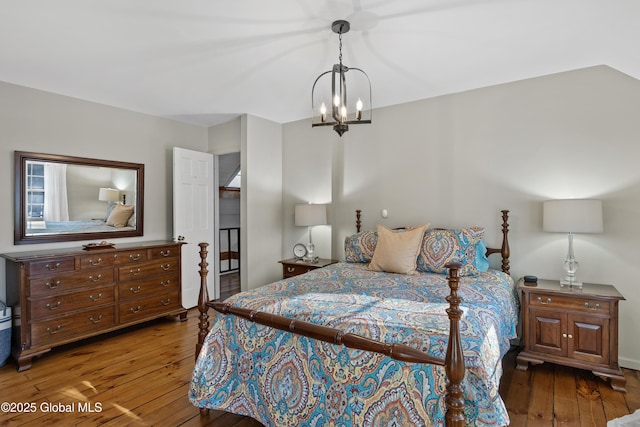 bedroom with hardwood / wood-style flooring and a notable chandelier