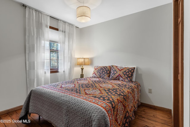 bedroom featuring baseboards and wood-type flooring