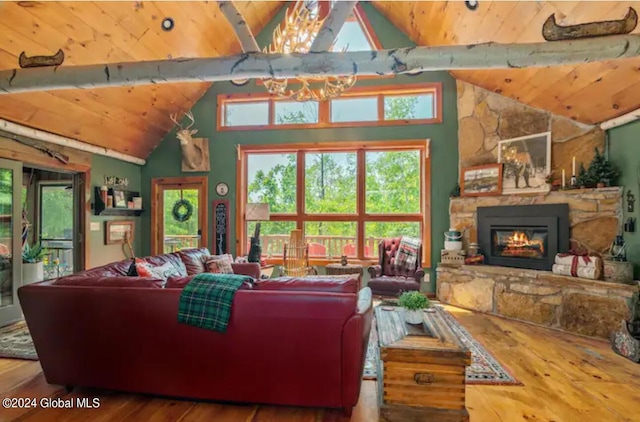 living area featuring wood ceiling, vaulted ceiling, a stone fireplace, and wood finished floors