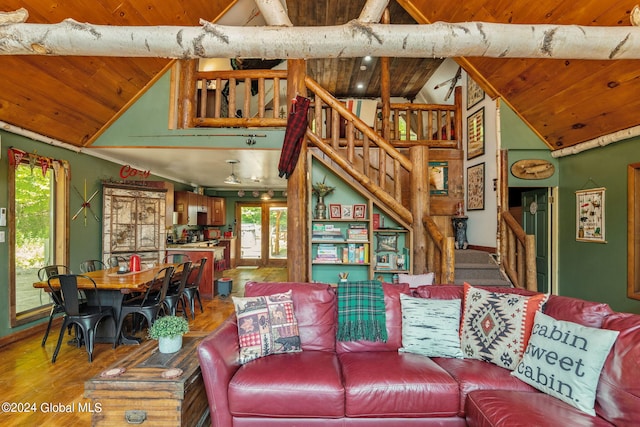 living area with high vaulted ceiling, wood finished floors, wood ceiling, and stairs