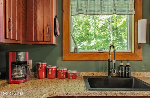 kitchen with brown cabinetry and a sink