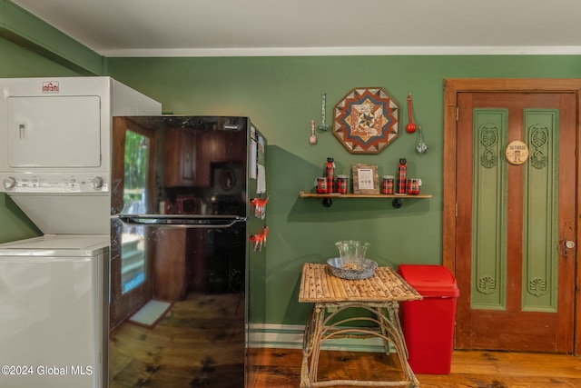 kitchen featuring stacked washer / dryer and wood finished floors