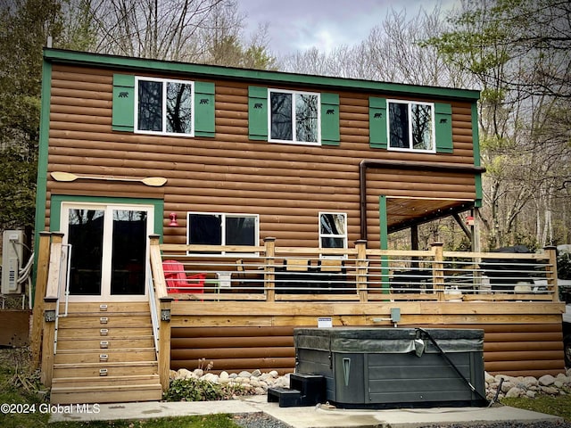 view of front facade featuring log veneer siding and a wooden deck